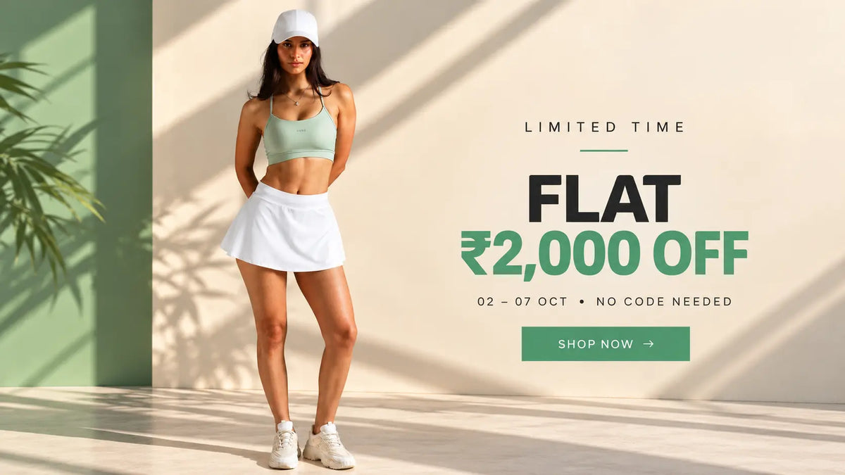 VARO activewear model wearing a sage green sports bra, white skort, white cap and sneakers in a sunlit studio, promoting a limited-time ₹2,000 off offer from 02–07 October 2026.