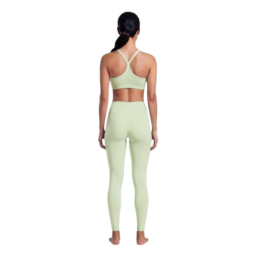 VARO On Repeat Bra in light green recycled nylon with a racerback design, worn by a model from the back view.