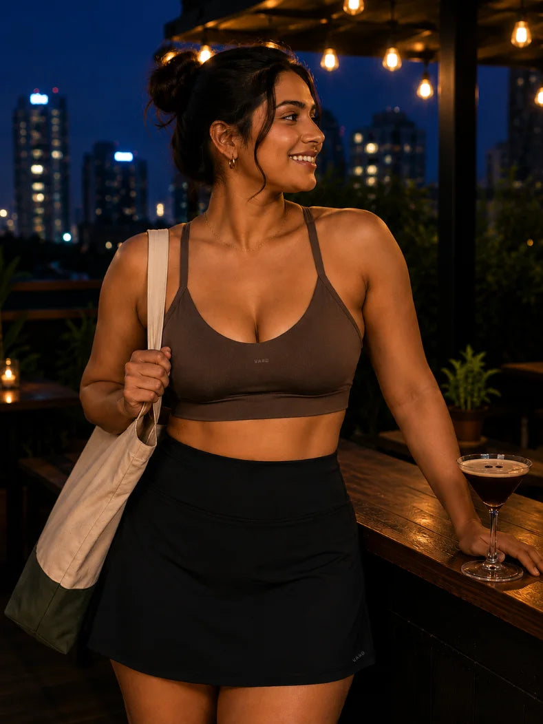 VARo Woman in athletic wear standing at a bar with cityscape in the background