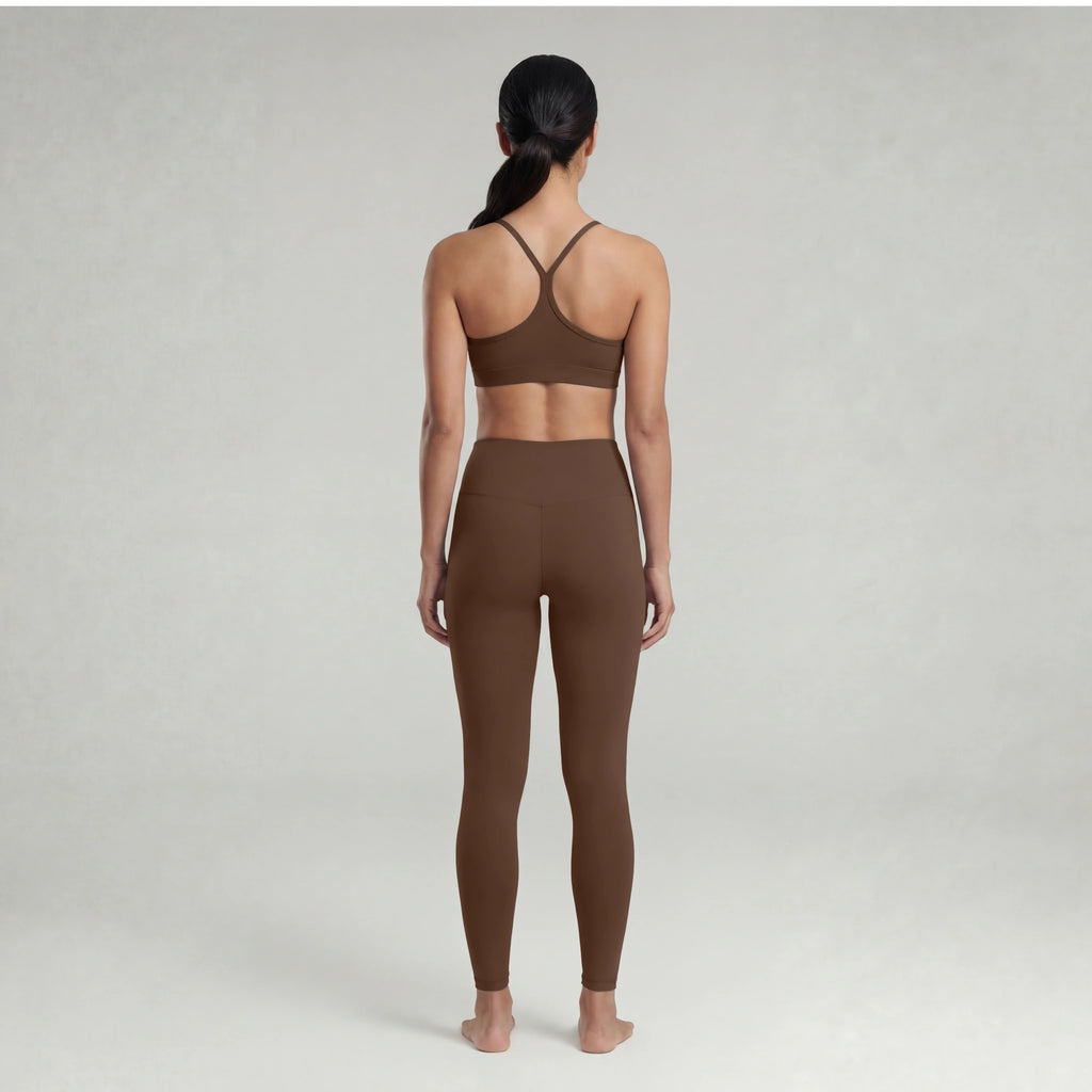 Woman wearing a chocolate brown sports bra and leggings