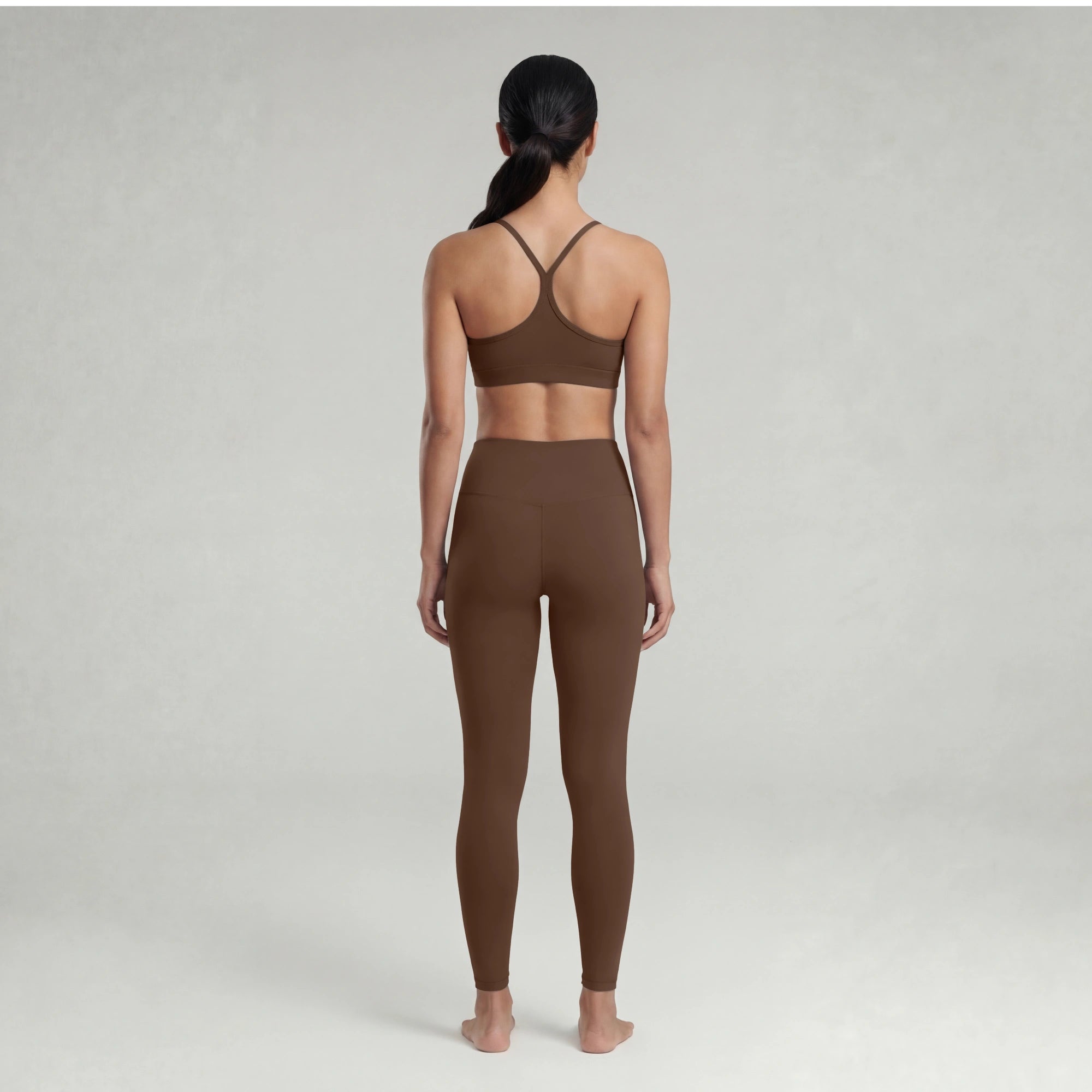 Woman wearing a chocolate brown sports bra and leggings