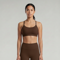 A woman is wearing a chocolate brown  sports bra  and chocolate brown pants