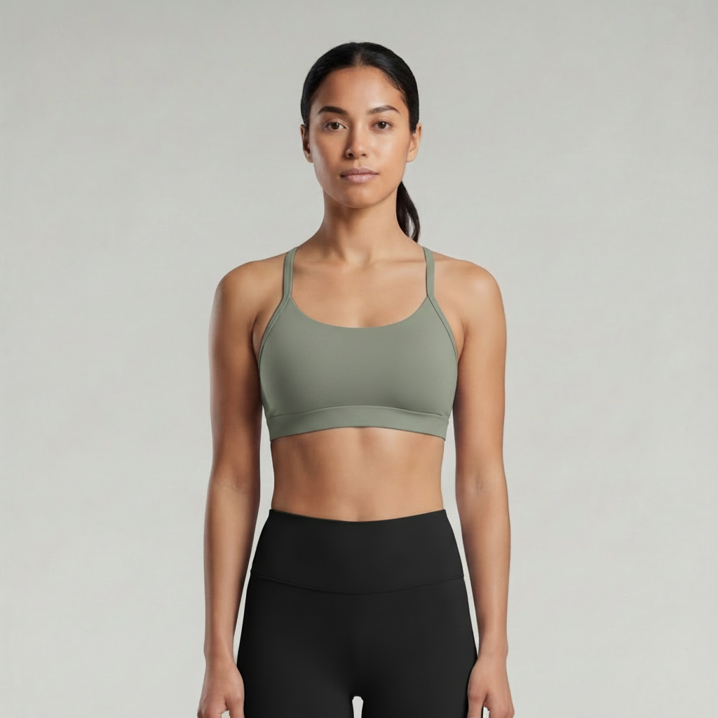 A woman is wearing a sage green brown  sports bra and black pants