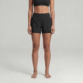 A woman wearing black athletic shorts and a black sports bra