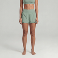 A woman wearing green athletic shorts and a green sports bra