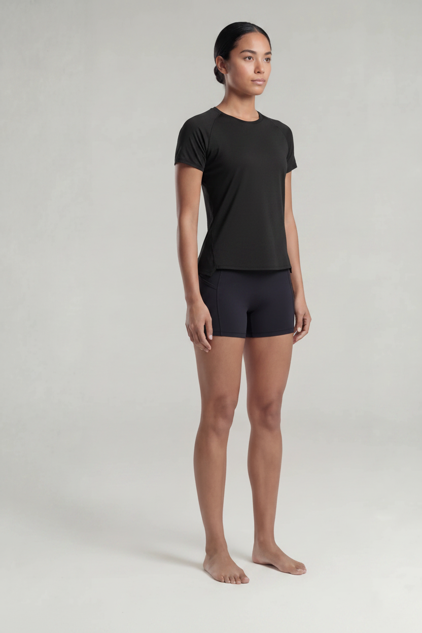 A woman wearing a black t-shirt and black shorts