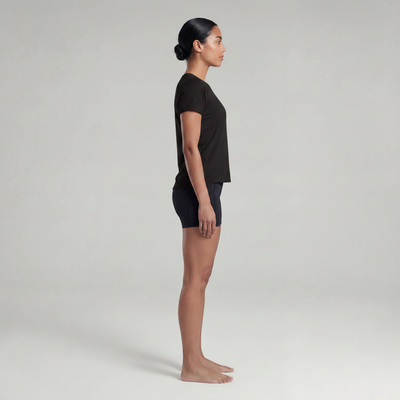 A woman wearing a black t-shirt and black shorts