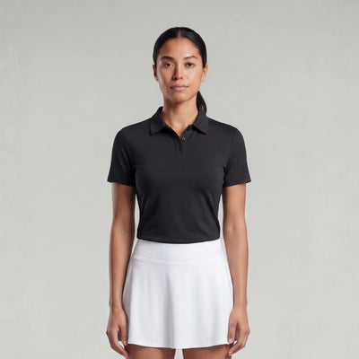Woman wearing a black polo shirt and white skirt on a gray background