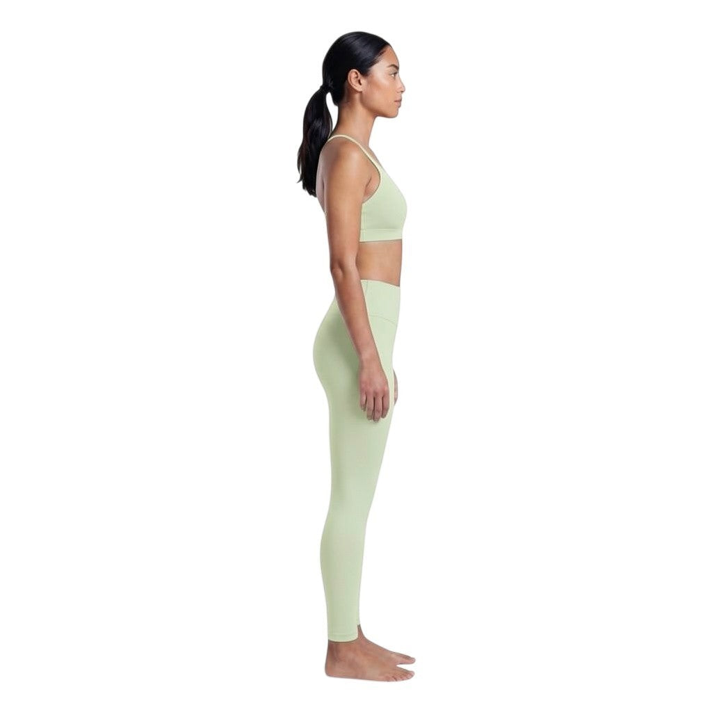 VARO On Repeat light green sports bra and matching leggings on a model, featuring soft recycled nylon knit fabric.